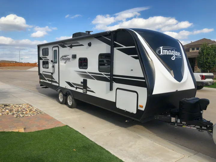 White and black Grand Design Imagine travel trailer parked, ready to be your next RV rental.. Grand Design Imagine 2019