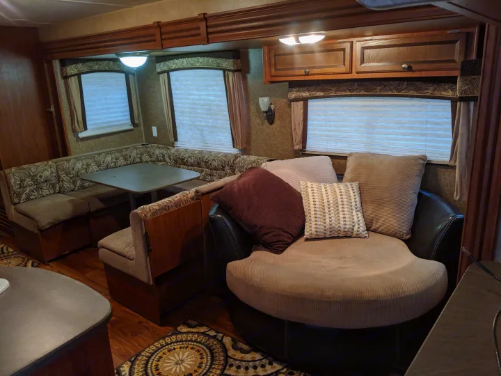 RV rental: spacious interior with a U-shaped dinette, dark wood accents, and a large, plush round chair.. Jayco Jay Flight 2012
