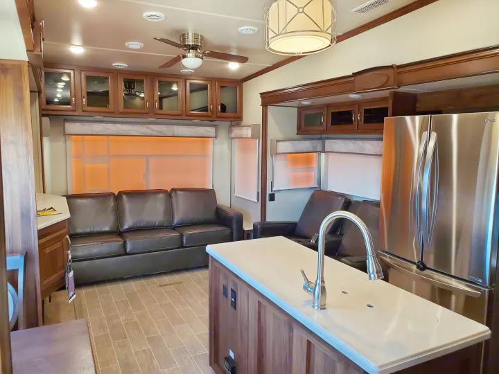 Explore this inviting RV rental interior: a modern kitchen island, comfy sofas in the living area, and a stainless steel fridge.. Palomino Columbus 2019
