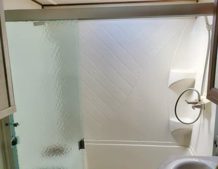 Bright RV rental interior: functional shower with textured glass sliding door and compact tub.. Palomino Columbus 2019