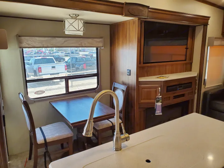 Spacious RV rental interior featuring a dinette, kitchen island, and entertainment center with a fireplace and TV.. Palomino Columbus 2019