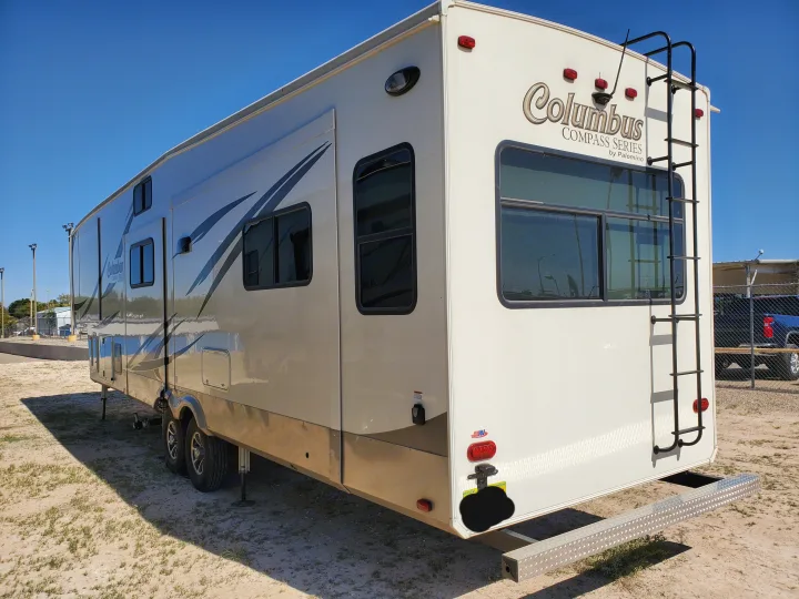 Spacious beige fifth-wheel RV rental by Columbus, featuring side slides & a rear ladder, parked for your next camping trip.. Palomino Columbus 2019