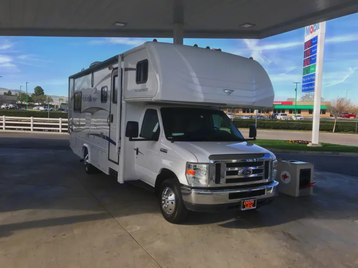 White Fleetwood Tioga Ranger RV rental getting gas at a Mobil station. Perfect for a travel adventure or road trip!. Fleetwood Tioga Ranger 25G 2011