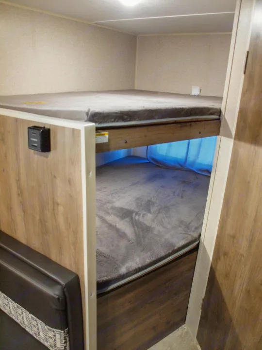 RV rental interior: cozy bunk beds with soft mattresses & a charging port.. Dutchmen Aspen Trail LE 1950BH 2020