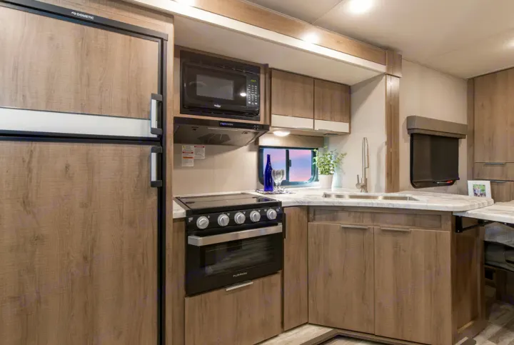 This rv rental features a fully equipped kitchen with refrigerator, oven, microwave, and sink, making travel convenient.. Grand Design Imagine XLS 19BWE 2020