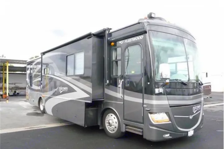 Spacious dark grey Fleetwood Discovery motorhome with slide-out extended, perfect for your next RV rental adventure or luxurious travel.. Fleetwood Discovery 2006