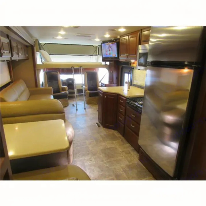 Spacious RV rental interior with kitchen, living area, and overhead bunk bed for comfortable travel.. Thor Palazzo 2014