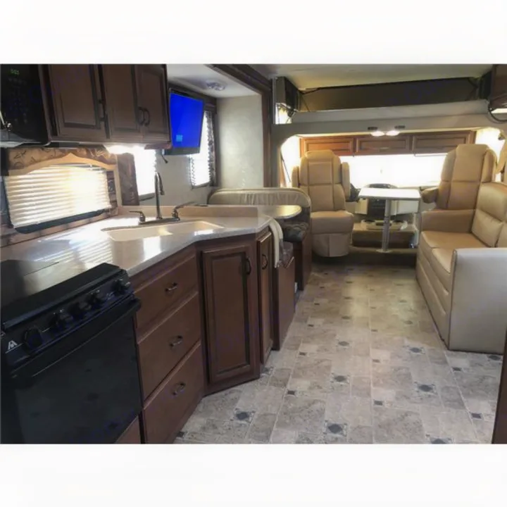 Spacious RV rental interior with kitchen, dining booth, and living area. Comfortable motorhome for travel.. Thor Hurricane 2014