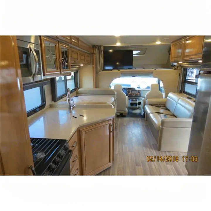 Spacious RV rental interior with a full kitchen on the left, living area, and driver's cockpit upfront.. Thor Quantum 2017
