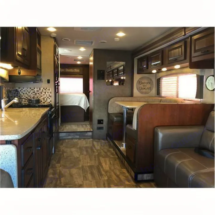 Explore this RV rental's interior: dark wood kitchen, dining booth, comfy sofa, and rear bedroom.. Forest River Forester 2016