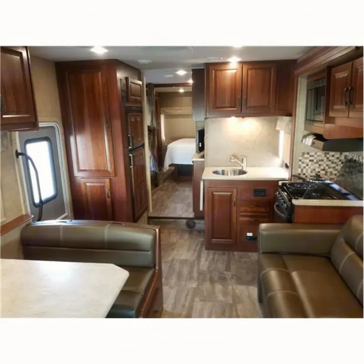 Explore this RV rental's spacious interior: full kitchen, dining booth, sofa, and private bedroom area.. Forest-River Forester 2017