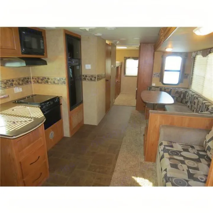 RV rental interior showcasing a kitchen with stove, refrigerator, dinette seating, and sofa. Ideal for family trips.. North-Trail Heartland 2011