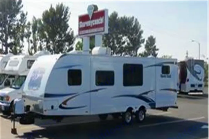 RV rental: A white travel trailer with blue graphics, parked on a lot under a "ShareMyCoach!" sign.. North-Trail Heartland 2011