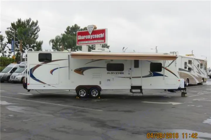White travel trailer RV with awning extended, parked on a paved lot. A sign advertises RV rental services.. Forest-River Surveyor 2011