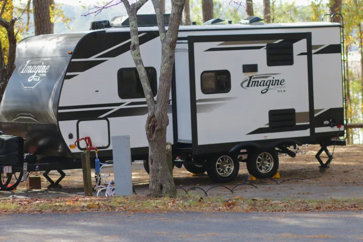 Travel trailer RV rental (Imagine XLS) parked at a fall campsite with power & water hookups.. Grand Design Imagine XLS 19BWE 2020
