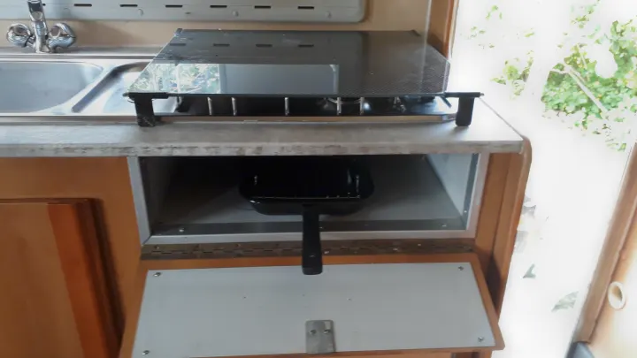 Inside your rv rental: a compact kitchen with a sink, covered gas stove, and handy storage for cookware.. Fiat Ducato Bessacarr E625 2000