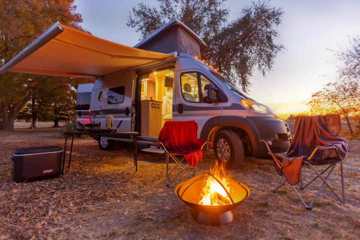 RV rental parked with awning extended, chairs, fire pit, and cooler for a cozy sunset camping trip.. Hymer Other 2019