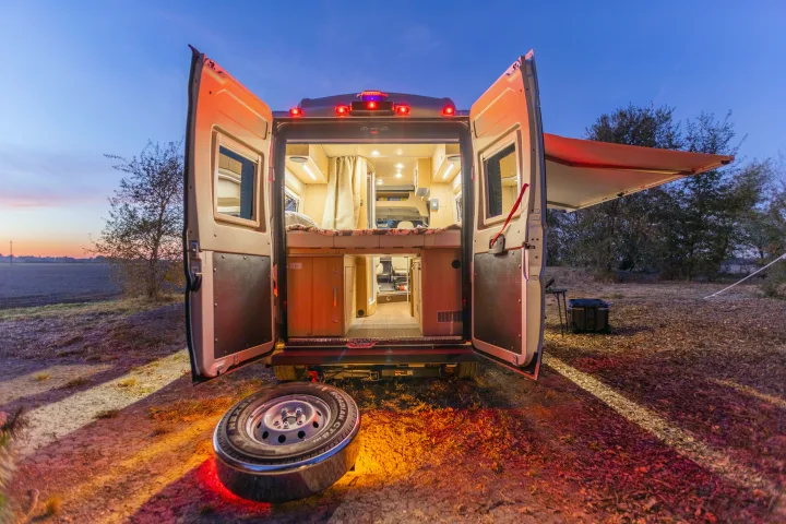 Cozy RV rental interior at dusk, seen from open rear doors, parked for an outdoor adventure.. Hymer Other 2019