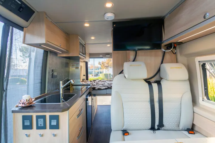 Spacious RV rental interior with modern kitchen, comfy passenger seats, TV, and rear bed for road trip adventures.. Hymer Other 2019