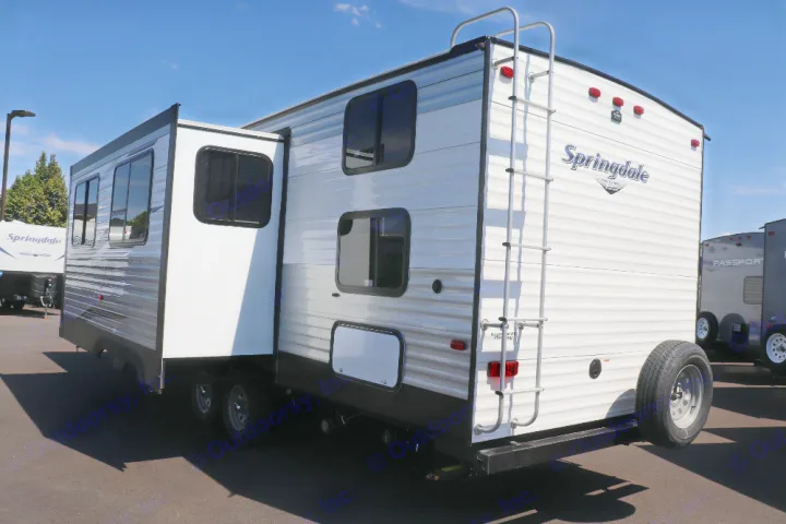 White travel trailer, featuring a slide-out and rear ladder, available for RV rental camping trips.. Keystone Springdale 2020