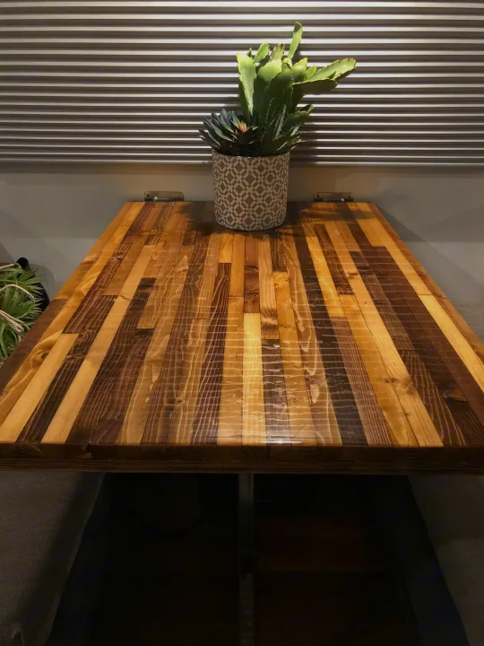 RV rental's custom wooden table and potted plant against ribbed blinds, offering a cozy and functional space.. Fleetwood Flair 1997