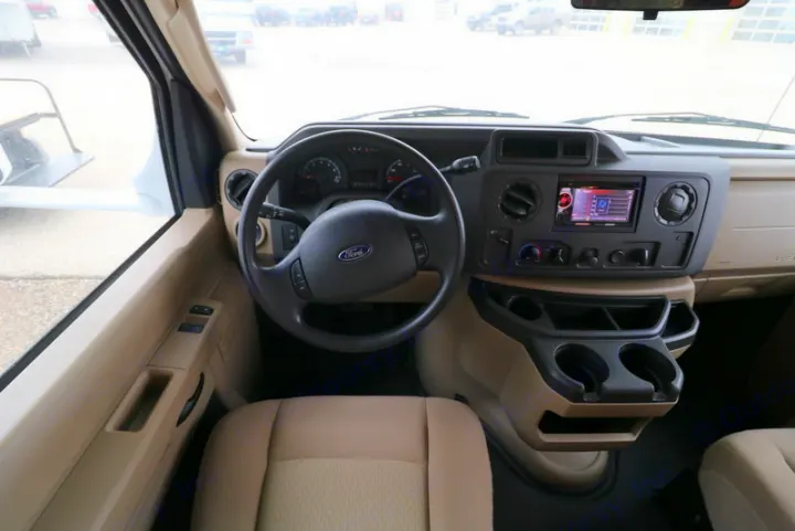 Inside an rv rental: Ford cockpit with beige interior, modern infotainment, and practical storage for your journey.. Thor Motor Coach Freedom Elite 2013