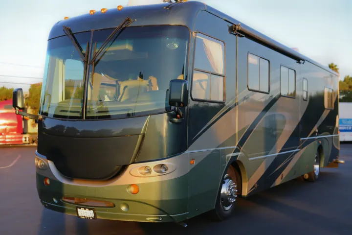 Sleek dark green and grey motorhome, parked and ready for your next rv rental adventure on the road.. Coachmen Cross Country 2005