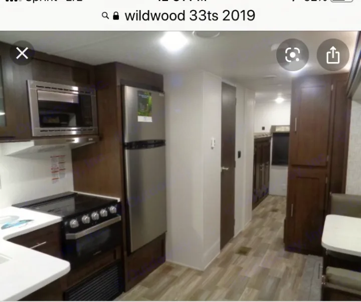 Kitchen with refrigerator, gas stove, microwave, and tall double door pantry. . Wildwood 32qbss 33ts 2019