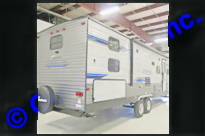 This spacious gray travel trailer, with blue accents and an extended slide-out, is parked indoors. Perfect for your next RV rental adventure.. Coachmen Catalina 2019