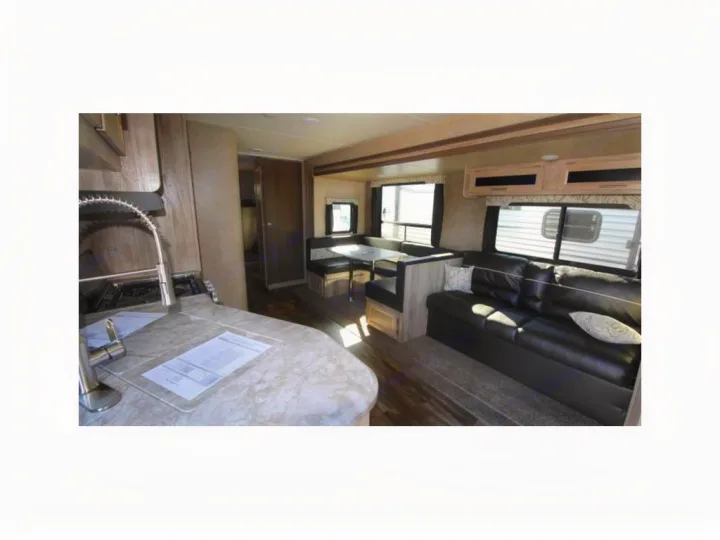 Spacious RV rental interior featuring a full kitchen, comfortable dining booth, and a cozy living room sofa.. Coachmen Catalina 2019