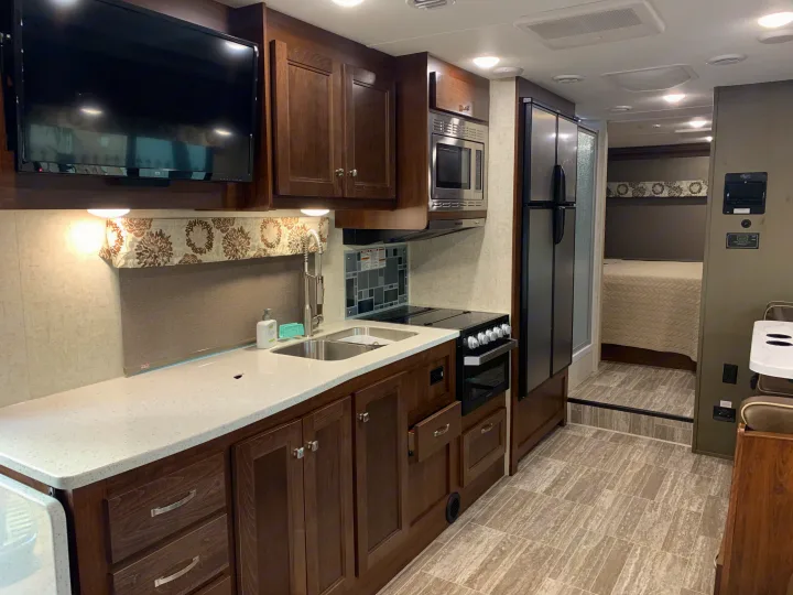 RV rental: Modern RV interior features kitchen with double sink, oven, fridge, living area with TV, and a cozy bedroom.. Forest River Forester 2020