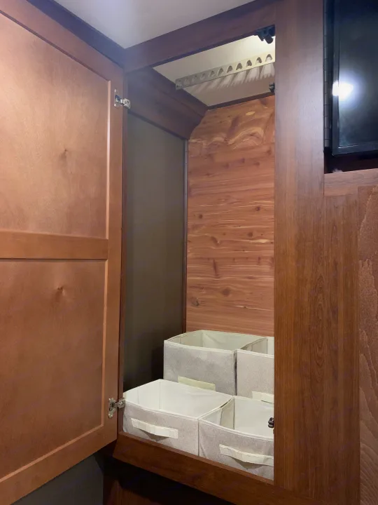 RV rental wardrobe with aromatic cedar lining, a hanging rack, and light gray fabric storage bins for organized living.. Forest River Forester 2020
