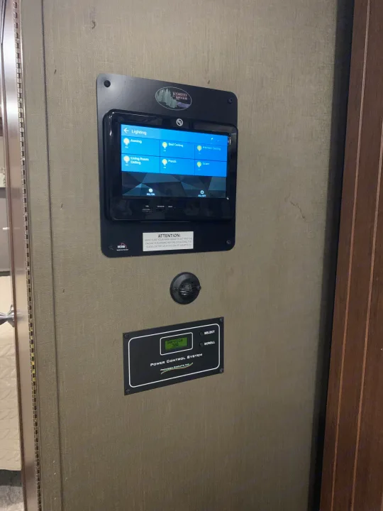 An RV rental's digital control panel showing lighting options (Awning, Porch, Ceiling) and a power control system (Service 30A).. Forest River Forester 2020