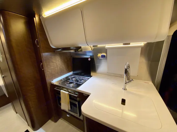 Explore this bright, functional RV rental galley. Features a modern sink, stovetop, and oven in a compact design.. Airstream Globetrotter 2020
