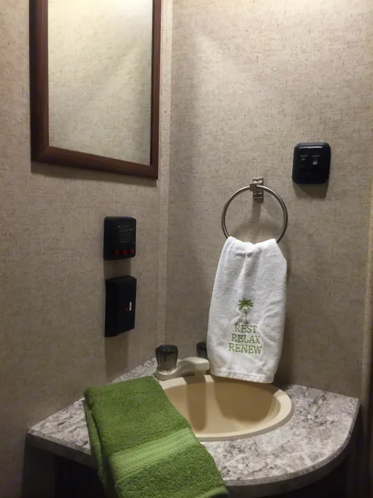 RV rental bathroom featuring a sink, mirror, digital panel, and fresh towels. Compact and convenient for your trip.. Heartland Prowler Lynx 2016