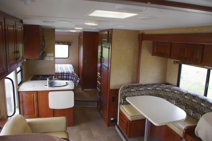 Spacious RV rental interior: well-equipped kitchen, comfy dinette, and rear bedroom for convenient mobile living.. Forest River Sunseeker 2015