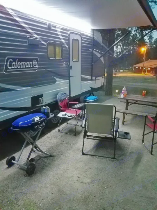 Enjoying an evening at the campsite with an RV rental, featuring a grill, chairs, and picnic table under the awning.. Coleman Coleman 202RD 2017