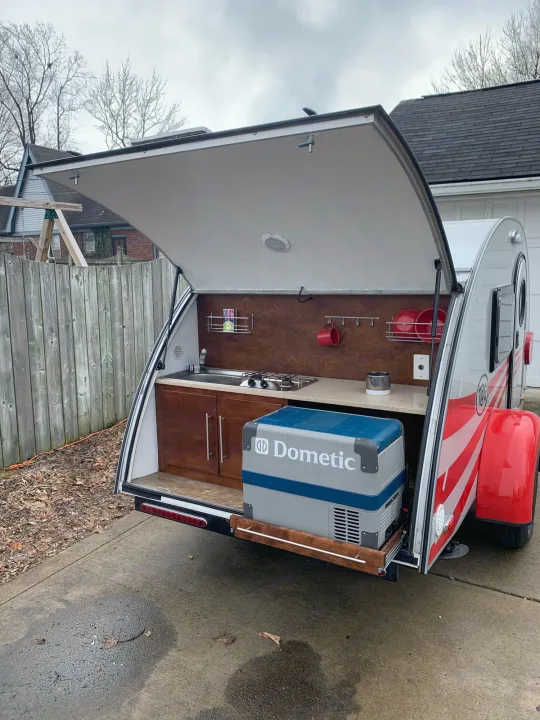 Explore this RV rental's clever rear outdoor kitchen, featuring a sink, stove, and pull-out Dometic cooler, ideal for camping.. T@G T@G Trailer 2016
