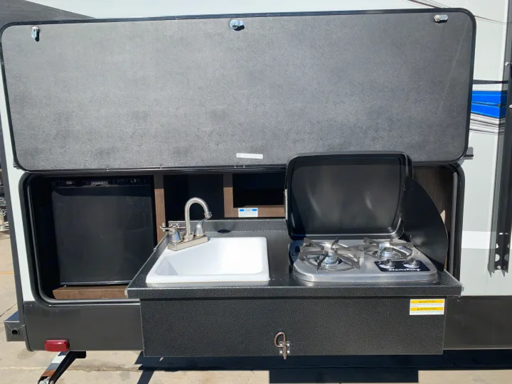This RV rental features a convenient slide-out outdoor kitchen with a fridge, sink, and two-burner stove, ideal for camping.. Cruiser Rv Corp Shadow Cruiser 2019
