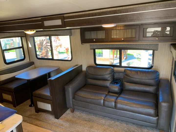 Spacious RV rental interior with dinette & comfy sofa, perfect for travel.. Cruiser Rv Corp Shadow Cruiser 2019