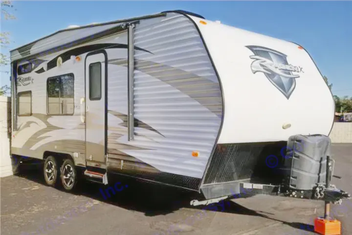 A large, grey and white travel trailer, perfect for an RV rental, is parked outside. This recreational vehicle is ready for adventure.. Pacific Coachworks Rage'N 2014