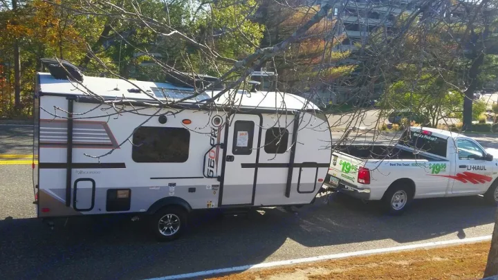 A white Rockwood GEO PRO RV (SOLD) is towed by a white U-Haul rental pickup truck. A solution for RV transport, complementing an rv rental service.. Forest River Rockwood 2018