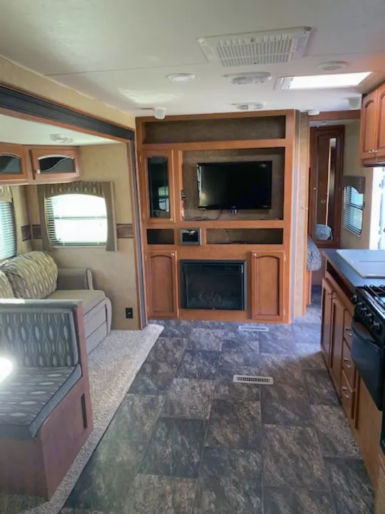 RV rental interior featuring a bright living space, TV, kitchen, and elevated sleeping area.. Shasta Revere 2012