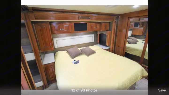 Comfortable RV rental bedroom featuring a queen bed, overhead cabinets, a TV area, and convenient bunk beds.. Holiday Rambler Endeavor 2018