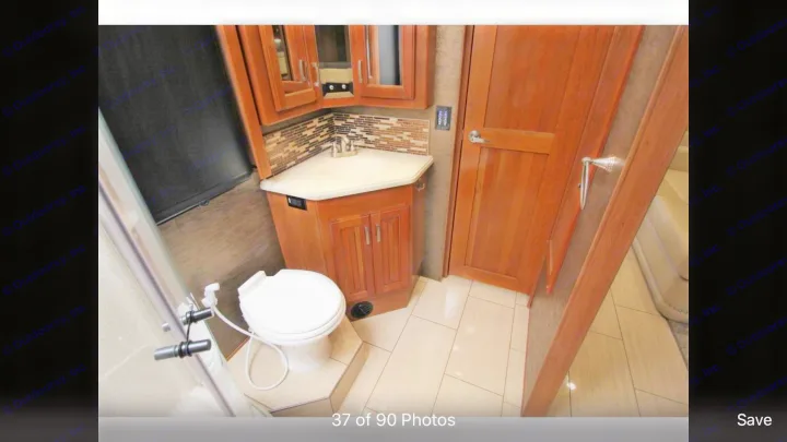 RV rental bathroom with toilet, sink vanity, mirrored cabinet, and shower. Features light-colored tiled floor.. Holiday Rambler Endeavor 2018