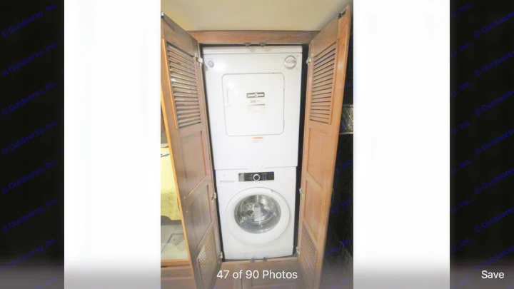 RV rental: View of built-in stacked washer/dryer in a compact wood cabinet, offering onboard laundry.. Holiday Rambler Endeavor 2018