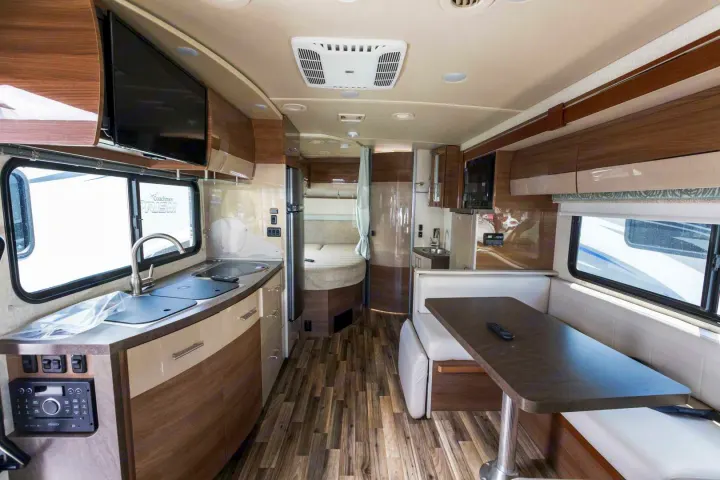 Spacious, well-equipped rv rental interior featuring a full kitchen, dining booth, and sleeping area with modern finishes.. Winnebago View 2017