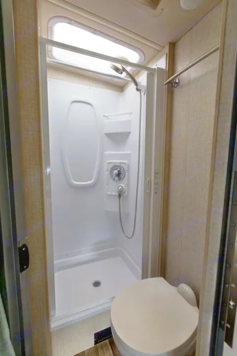 RV rental bathroom: compact design with white shower stall, skylight, and toilet for comfortable travel.. Winnebago View 2017