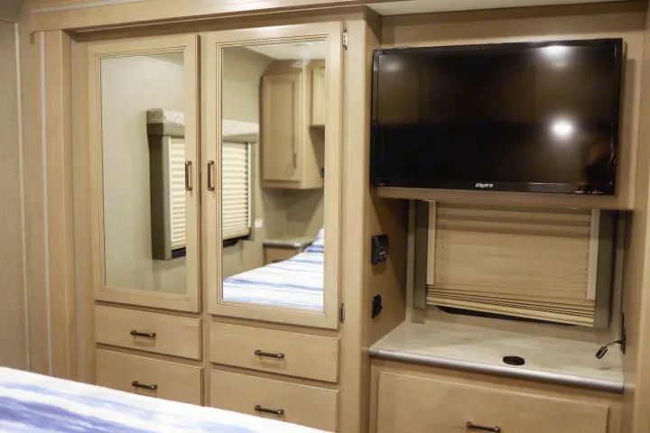 Armoire with lots of drawers and stash area behind TV. Thor Motor Coach A.C.E 2020