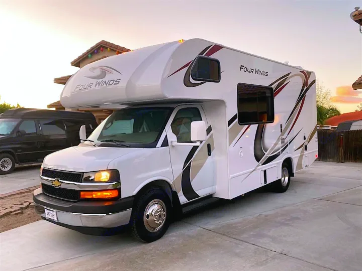 Experience travel freedom! This pristine white Four Winds Class C motorhome, ideal for rv rental, is parked and ready for adventure.. Thor Motor Coach Four Winds 2020